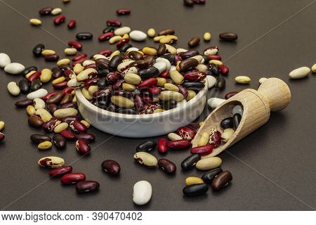 Mix Of Various Dry Legumes In Ceramic Bowl, Scattered On Black Stone Background