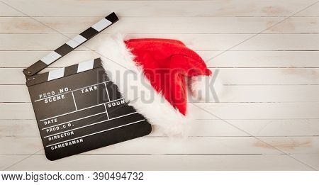 Santa Calus hat and movie clapper on a white background