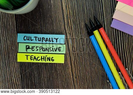 Culturally Responsive Teaching Write On Sticky Notes Isolated On Wooden Table. Educational Concept