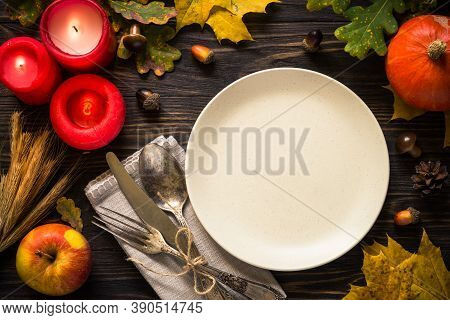 Thanksgiving Food Concept. Autumn Table Setting With Craft Plate, Silverware And Fall Decorations At