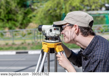 Samara, Russia - June 12, 2019: Surveyor Engineer Worker Making Measuring With Geodetic Optical Leve