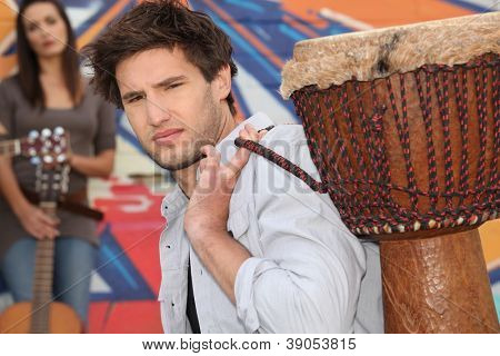 Jovem carregando um djembe