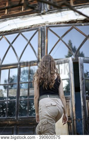 Young Woman With Curly Hair Near Large Windows