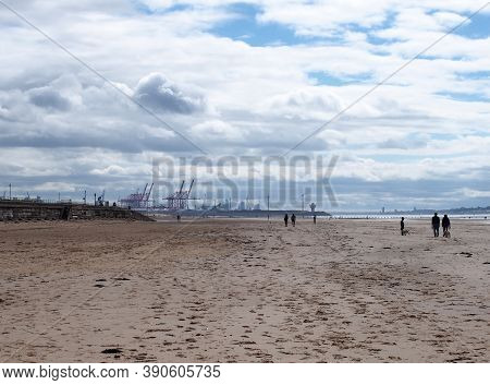 Southport, Merseyside, United Kingdom - 10 September 2020: People Walking On The Beach With Dogs At 