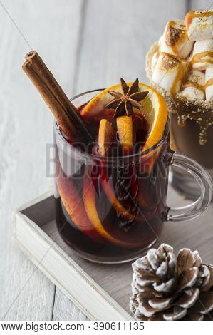 Two Traditional Christmas Hot Beverages - Mulled Wine With Orangle Slices And Cinnamon Sticks And Ho