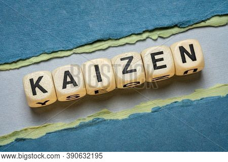 kaizen word abstract in wooden letter cubes against paper abstract in green tones,  Japanese continuous improvement and a change for better concept