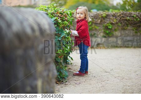 Adorable Toddler Girl In Red Poncho Walking In Autumn Park. Happy Kid Enjoying Fall Day In Paris, Fr