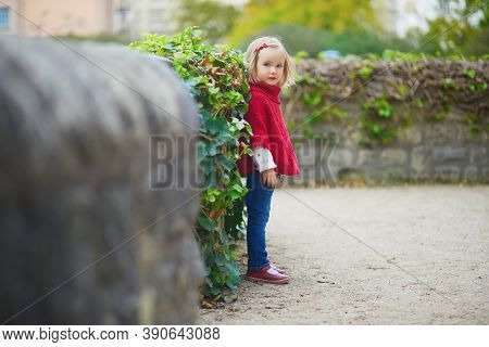 Adorable Toddler Girl In Red Poncho Walking In Autumn Park. Happy Kid Enjoying Fall Day In Paris, Fr