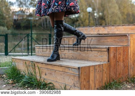 A Beautiful Girl Walks Up The Stairs And In A Burgundy Palette And Biret, Smiles At The Camera In Bl