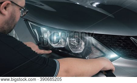 Worker Pastes Over Headlamp Optics With Special Tape Around Perimeter, Prepares For Polishing.