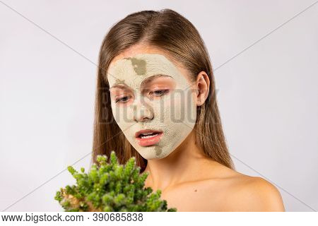 A Young Blondine Girl In A Spa Treatment Room With A Clay Mask On Her Face And A Juicy Cactus In Her