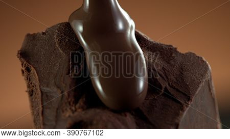 Detail of piece of chocolate with pouring hot chcocolate on top. Studio macro shot.