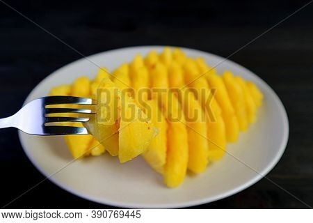 Closeup A Chunk Of Fresh And Juicy Pineapple With Blurry Slices Of Pineapple In The Backdrop