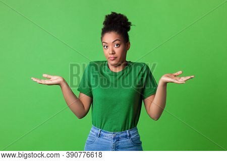 Who Knows. Portrait Of Funny Young Black Woman Shrugging Shoulders Looking At Camera Posing Over Gre