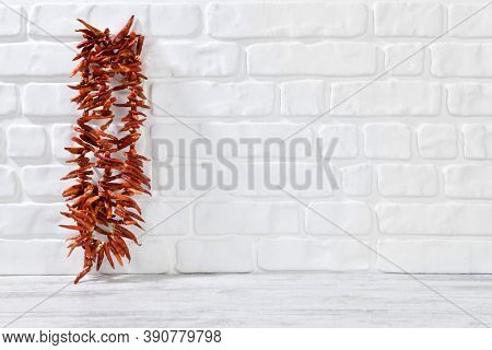 Bunch of red hot chili pepper on decorative stone wall background 
