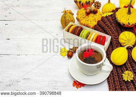 French Macarons In Autumn Colors With Cup Of Hot Tea