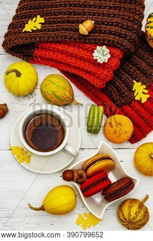 French Macarons In Autumn Colors With Cup Of Hot Tea