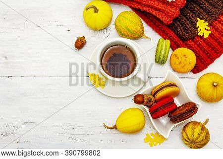 French Macarons In Autumn Colors With Cup Of Hot Tea