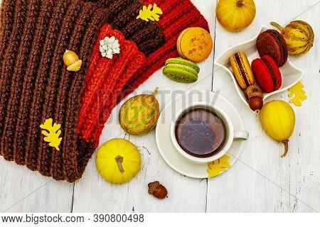 French Macarons In Autumn Colors With Cup Of Hot Tea