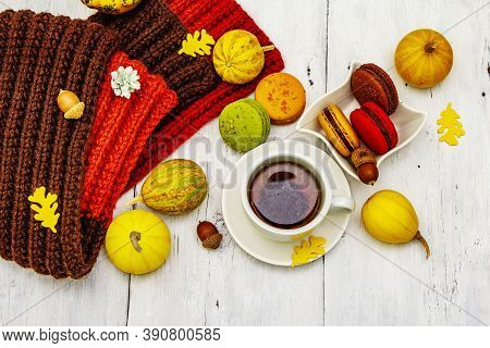 French Macarons In Autumn Colors With Cup Of Hot Tea