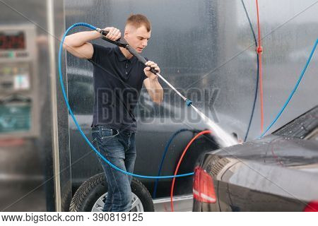 Car Washing. Cleaning Car Using High Pressure Wax For Shinig. Man Washing His Car Outdoor