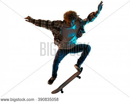 one cauacsian young man skateboarder Skateboarding in studio silhouette shadow isolated on white background