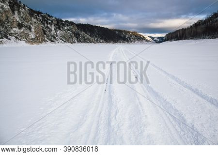 Tire Tracks In The Snow, Winter Road, Empty Road In Winter Goes Far To The Horizon, Covered With Sno