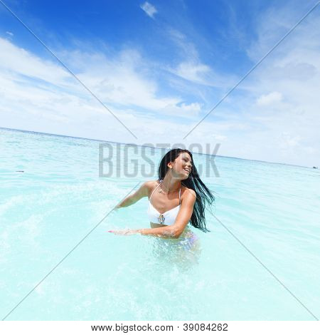 Vrolijke vrij jonge vrouw splashin in zee