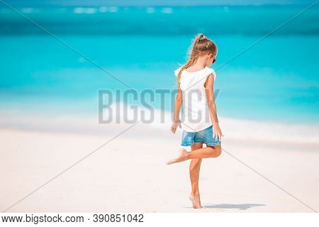 Adorable Active Little Girl At Beach During Summer Vacation