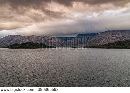 Sarmiento Channel, Chile - December 11, 2008: Amalia Glacier And Fjord. Thick Brown Cloudscape Above