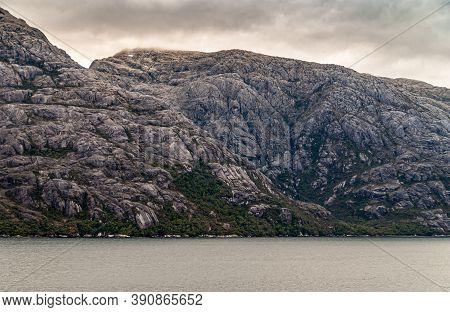 Sarmiento Channel, Chile - December 11, 2008: Amalia Glacier And Fjord. Closeup Of Gray Rocky Cliffs