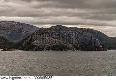 Sarmiento Channel, Chile - December 11, 2008: Amalia Glacier And Fjord. Brown Cloudscape Over Dark R