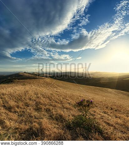 wind turbines on ridge of mountains in Sicily at the sunset