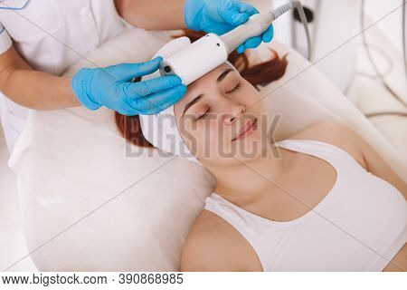 Top View Of A Young Woman Relaxing At Cosmetology Clinic, Getting Endospheres Facial Massage