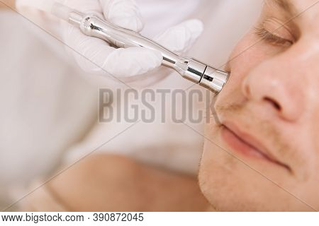 Cropped Close Up Of A Relaxed Man Having Facial Skincare Treatment By Professional Cosmetologist At 