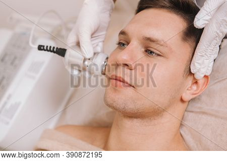 Close Up Of A Handsome Young Man Having Facial Skincare Treatment At Beauty Clinic
