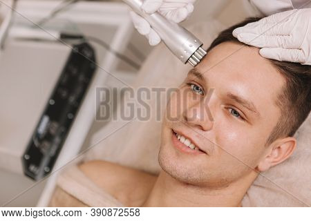 Cropped Shot Of A Happy Handsome Young Man Getting Ultrasound Facial Skincare Treatment At Beauty Sa