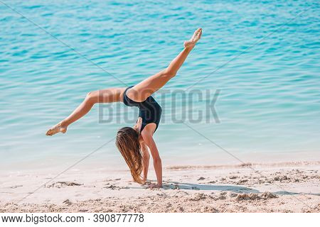 Adorable Active Little Girl At Beach During Summer Vacation