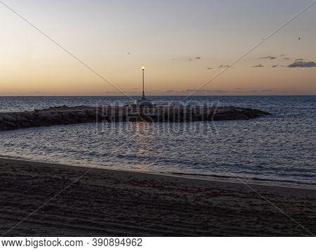 View Of The Sea And Stones On The Pedregalejo Beach At Dusk.