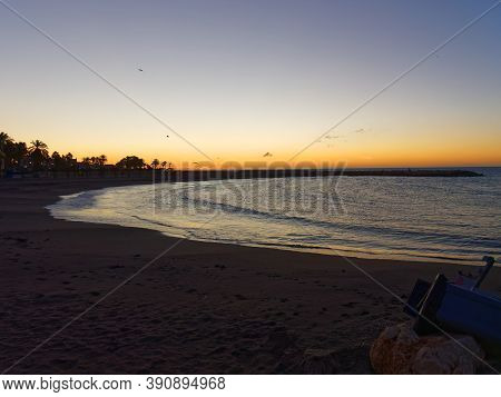 View Of The Sea And Stones On The Pedregalejo Beach At Dusk.