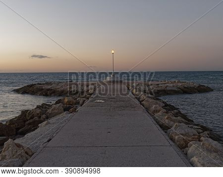 View Of The Sea And Lamppost On The Pedregalejo Beach At Dusk.