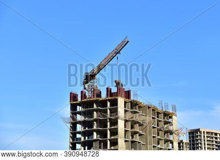 Preparing To Pour A Bucket Of Concrete Into Formwork.tower Crane Lifting Cement Bucket During Constr
