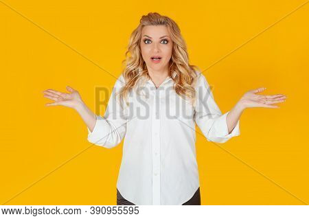 A Clumsy European Blonde Woman In A White Shirt, Shrugging Her Shoulders To The Sides, Not Suspectin