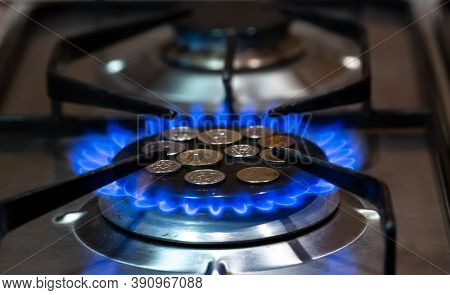 Coins Lie On The Stove Burner On Which The Gas Is Turned On