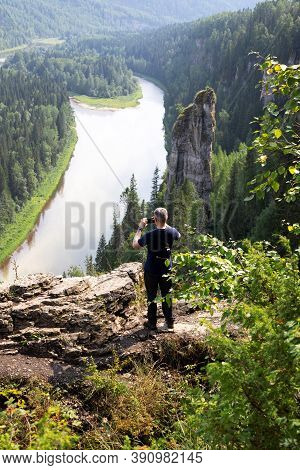 Caucasian Man Stands With His Back Turned And Making Photo Of Beautiful Landscape Of Devils Finger O