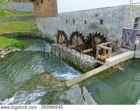 View On Waterfall, Mill In White Building, Pedestrian Bridge In Park Postojna Jama Near Postojna Cav