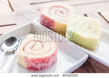 Colorful Jam Rolls On White Dish With Spoon And Fork