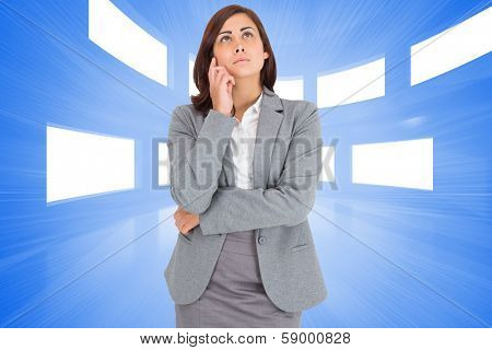 Thinking businesswoman against bright blue room with windows
