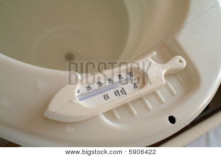 Thermomètre sur le rebord d'une baignoire de bébé