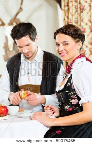 Couple in a traditional mountain hut having a meal